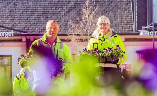 Anders och Johanna från Utegruppen poserar med blommor i sina famnar på Torget i Leksand